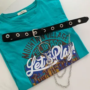 Punk style black grommet belt with metal chain and ring paired with a teal graphic t-shirt.
