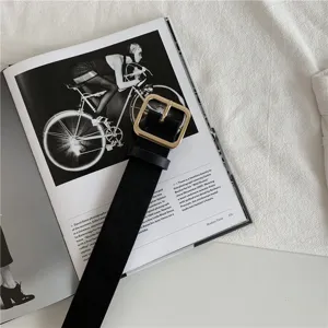 Detailed shot of a classic black women belt featuring a sleek square gold metal buckle.