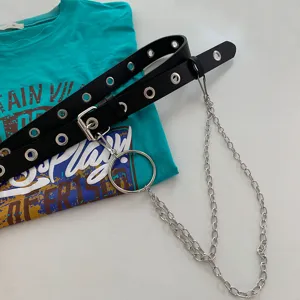 Punk style black leather grommet belt with metal ring and chains for jeans and trousers detail.