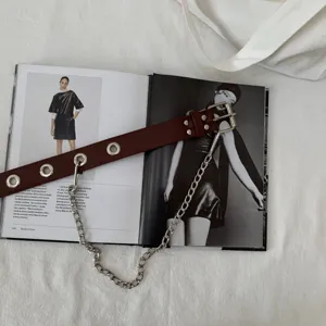 Detailed close-up shot of dark red leather waist belt with metal eyelets and chain