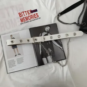 White punk style grommet belt detail featuring metal eyelets and dangling chain decoration.