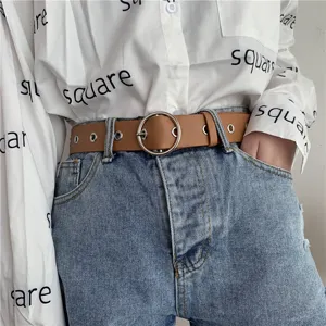 Detailed view of women casual brown leather belt with metal ring buckle and eyelet design.