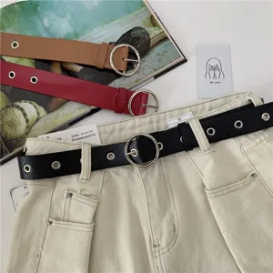 Detailed view of women's fashion leather belt featuring a sleek metal round buckle design.
