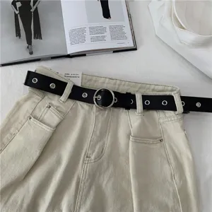 Classic black grommet belt with metal round buckle paired with casual light denim pants.