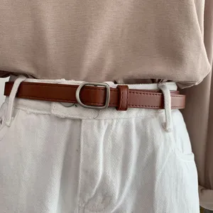Brown leather belt detail, metal D-ring buckle close-up, stylish accessory for casual jeans.