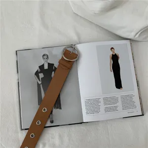 Stylish women brown PU leather belt with silver round metal buckle and eyelet details.