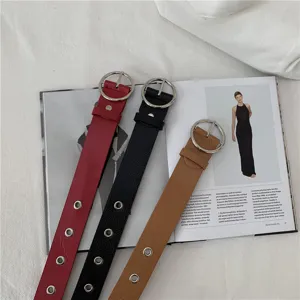 Detailed view of wide leather belts with metal round buckles and eyelet details in colors.