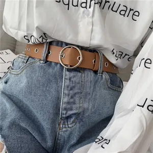 Detail shot of a stylish brown leather belt with metal ring buckle and eyelets for women.