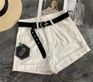 White denim shorts for women featuring black canvas belt and hexagonal buckle. Casual summer wear.