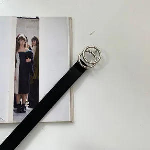 Minimalist black leather belt featuring a sleek double round silver metal buckle detail.