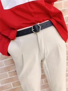 Close-up detail of the stylish black leather belt featuring a unique geometric hexagonal metal buckle.