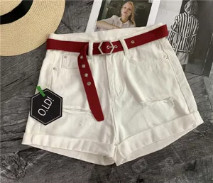 Close-up of white denim shorts featuring a red canvas belt and unique hexagonal metal buckle.