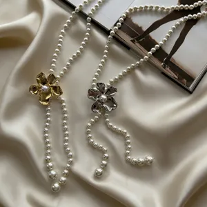 Chaine de taille elegante en perles avec pendentifs fleurs en metal, accessoire de luxe pour robe.