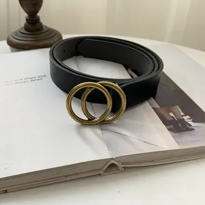 Vintage black leather belt with double interlocking brass rings for chic versatile outfits.