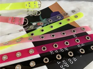 Detail shot showcasing colorful transparent PVC belts with metal grommets in various vibrant shades.