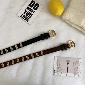 Ceinture fine en cuir polyvalente et décontractée pour femme avec œillets métalliques.