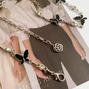 Silver metal waist chain with black enamel butterflies, rhinestones, and camellia floral pendant.