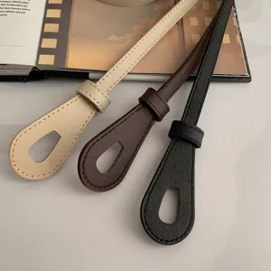 Gros plan de ceintures de taille décoratives en cuir PU mince en beige, marron et noir.