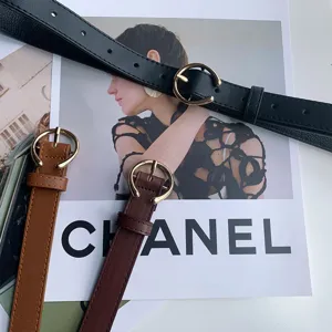 Detailed close-up of women minimalist leather belt with round metal pin buckle fashion style.