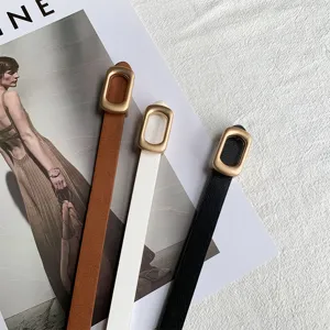 Minimalist thin leather belts detail shot showcasing brown, white and black colors with buckles.