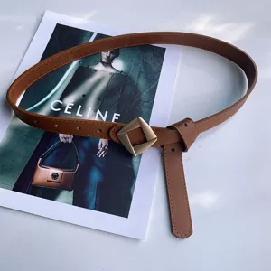 Detail view of women's brown leather belt with stylish geometric diamond buckle for casual jeans.