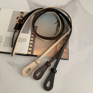 Vue détaillée de la fine ceinture en cuir en noir, marron et beige avec un design élégant.