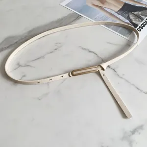 Cintura sottile da donna in pelle bianca con fibbia metallica dorata vista dettagliata.