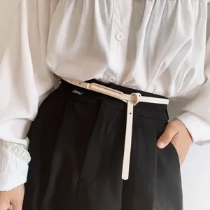 Primo piano dettagliato di una sottile cintura in pelle da donna con fibbia in metallo.
