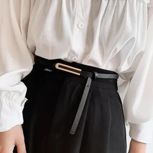Cintura sottile minimalista in pelle da donna con fibbia geometrica in metallo, dettaglio accessorio.