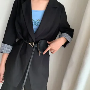 Cintura sottile in pelle nera da donna con fibbia triangolare e mini borsetta rotonda.