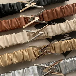 Stylish elastic waist belt for women featuring a chic triangular buckle. Perfect detail shot.