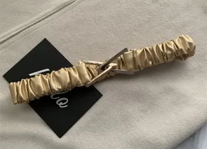 Gold elastic waist belt for women stretch wide cinch belt with unique metal triangle buckle.