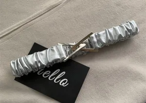 Detailed shot of the silver metallic elastic waist belt featuring a unique triangle buckle.