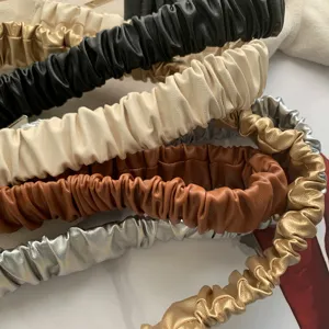 Women elastic wide belt closeup showing multiple colors like black gold brown and silver.