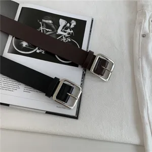 Detailed view of women's minimalist casual leather belt with silver square metal buckle.