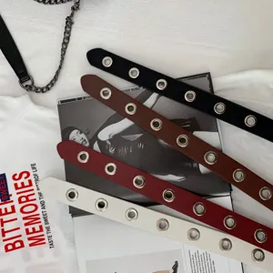 Close-up detail view of stylish women punk style metal grommet full hole decorative belt set.
