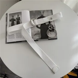 White canvas belt with metal double rings and chain pendant, minimalist trendy streetwear.