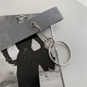 Detail view of grey canvas belt with metal rings, stylish accessory for casual cargo pants.