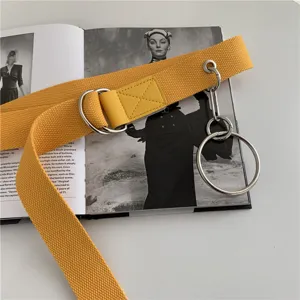 Trendy double ring canvas belt for women and men, stylish yellow waist strap with metal D-rings.