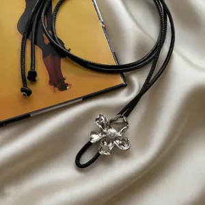 Elegant black leather cord belt featuring a chic silver flower pendant with a pearl center.
