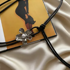 Chic soft leather waist belt featuring a metallic flower and pearl detail for women dresses.