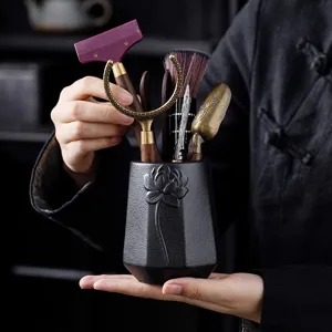 Traditional Chinese tea ceremony tool set with ceramic holder and wooden metal accessories.