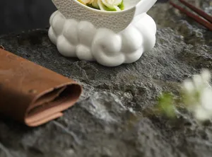 Détail de l'assiette croissant en céramique blanche avec socle nuage pour cuisine fusion.