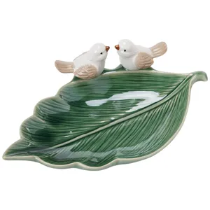 Ceramic green leaf jewelry tray with cute little birds, perfect for accessory storage.