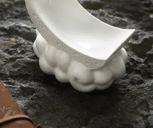 Détail assiette croissant céramique, présentation artistique élégante pour la cuisine fusion.