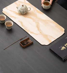 Detailaufnahme der zen-inspirierten wasserdichten Teematte mit goldenem abstrakten Muster.