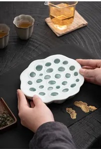 Detail shot of ceramic lotus seedpod teapot tray, elegant kung fu tea set accessory base.