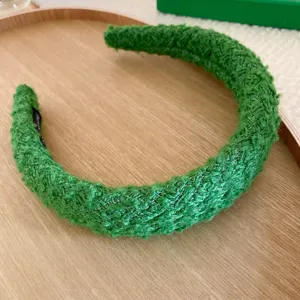 Dettaglio cerchietto intrecciato verde testurizzato, fascia per capelli invernale morbida, accessorio.