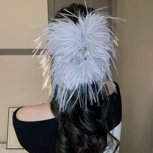 Vista dettagliata della molletta per capelli in piuma grigia soffice, elegante accessorio.