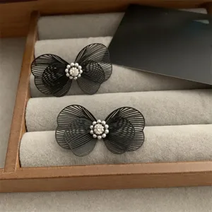 Élégante pince à cheveux nœud noir avec ailes en fil délicat, cristal étincelant et perles.